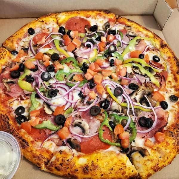 A Doughboys Pizzeria supreme pizza with pepperoni, ham, olives, onions, peppers, mushrooms, and tomatoes.